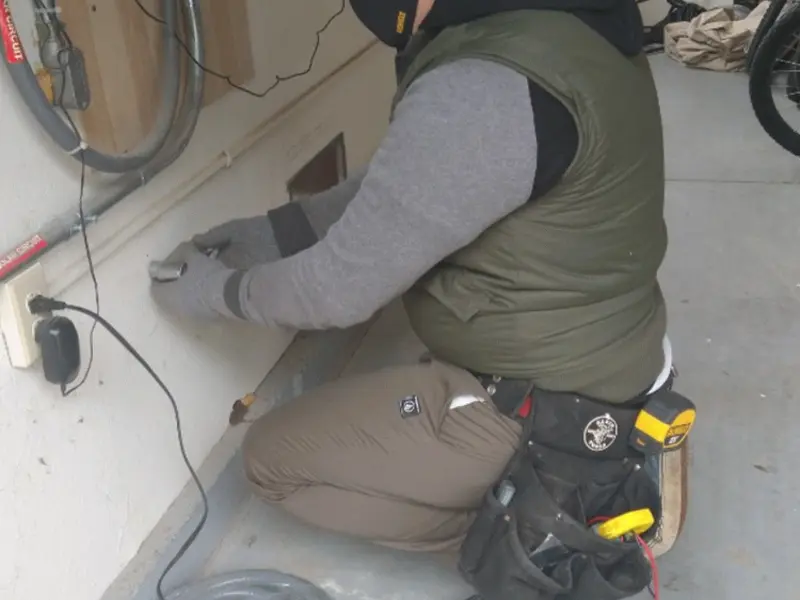 Electrician performing outlet wiring in a Fayetteville garage